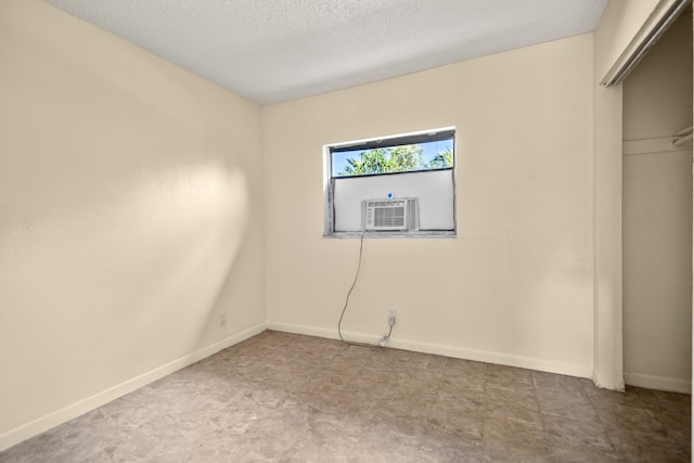 unfurnished room with cooling unit and a textured ceiling