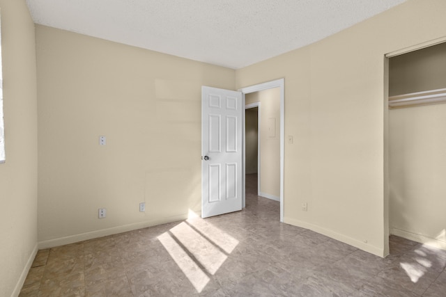 unfurnished bedroom with a textured ceiling and a closet