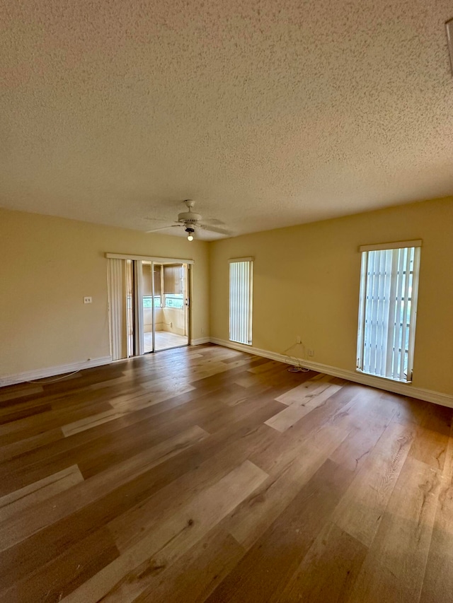 empty room featuring ceiling fan, a textured ceiling, and light hardwood / wood-style flooring