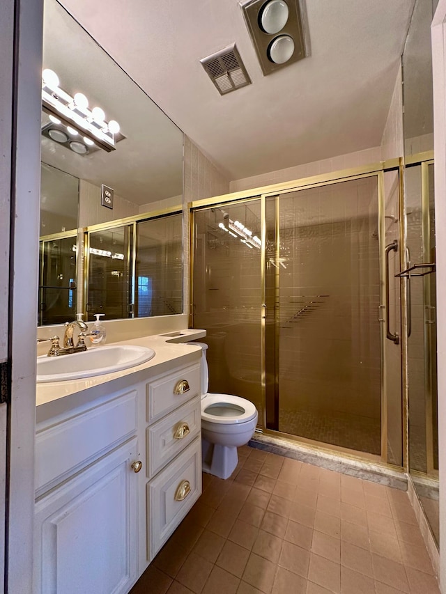 bathroom with vanity, tile patterned flooring, toilet, and an enclosed shower