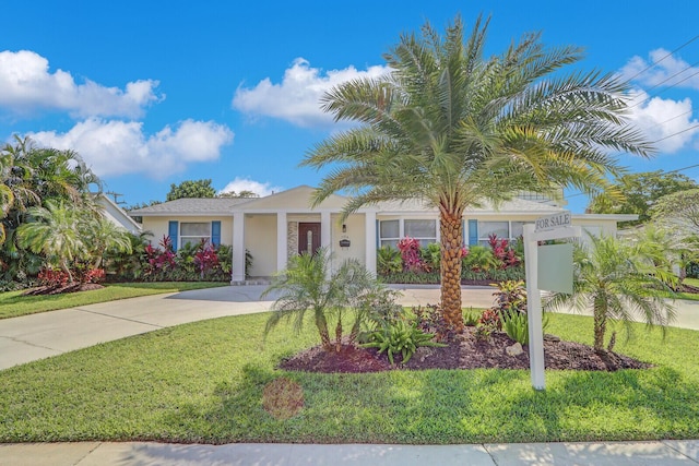 704 Eastwind Dr, North Palm Beach, FL 33408 - view of front of house with driveway, stucco siding, and a front lawn