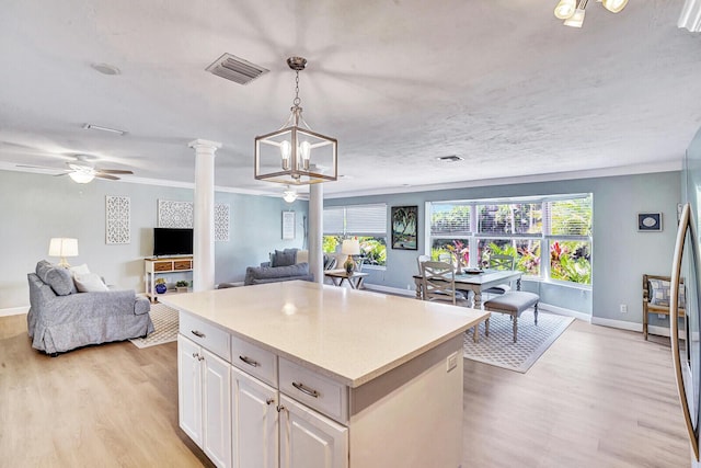 704 Eastwind Dr, North Palm Beach, FL 33408 - kitchen with light wood-style floors, light countertops, visible vents, baseboards, and white cabinets