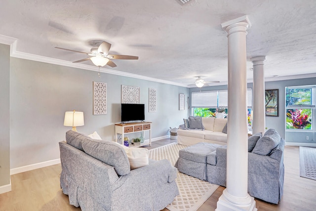 living room featuring a wealth of natural light, ornate columns, light hardwood / wood-style floors, and ceiling fan