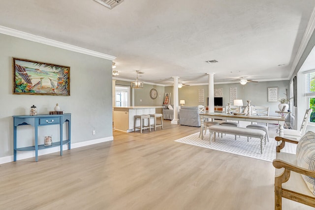 dining area with ornate columns, crown molding, and hardwood / wood-style flooring