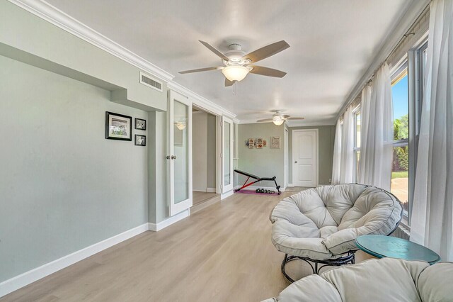 704 Eastwind Dr, North Palm Beach, FL 33408 - living area featuring visible vents, ornamental molding, a ceiling fan, and light wood finished floors