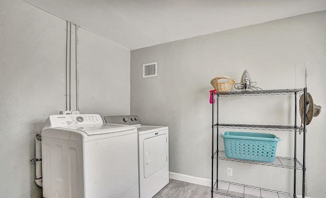 laundry room with light hardwood / wood-style flooring and separate washer and dryer