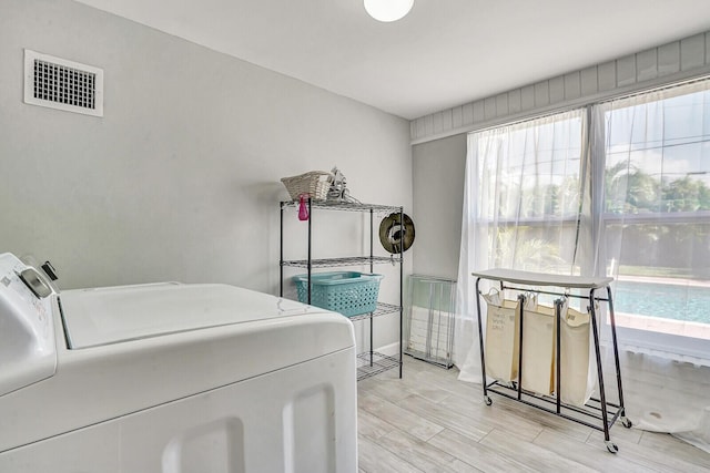 704 Eastwind Dr, North Palm Beach, FL 33408 - laundry room with visible vents, washing machine and clothes dryer, laundry area, and light wood-style floors