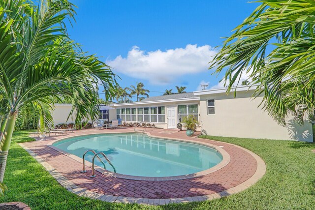 704 Eastwind Dr, North Palm Beach, FL 33408 - outdoor pool featuring a patio area and a yard