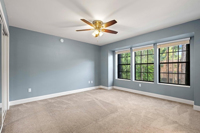 carpeted spare room featuring ceiling fan