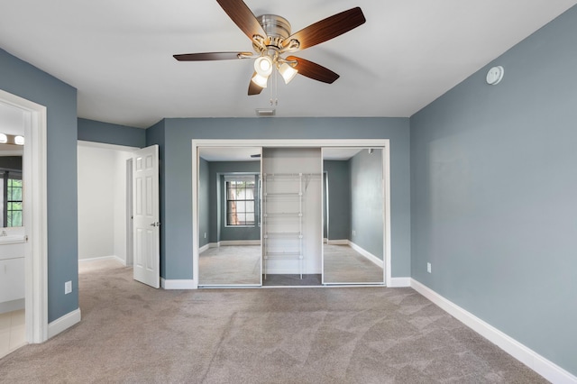 unfurnished bedroom featuring light carpet, a closet, and ceiling fan