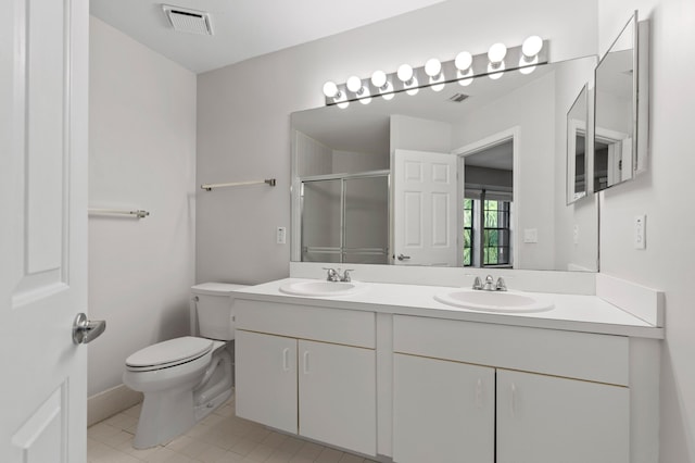 bathroom with toilet, a shower with shower door, vanity, and tile patterned flooring