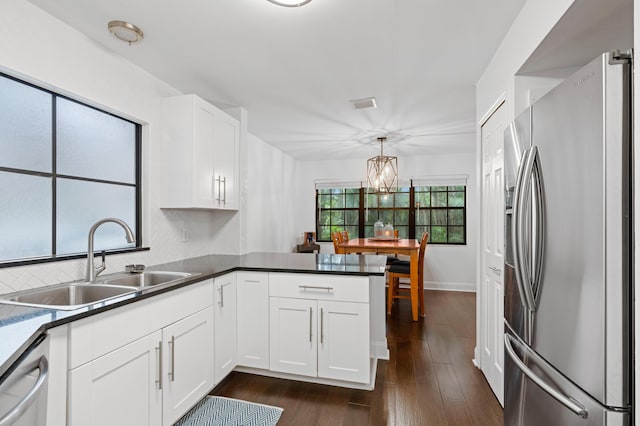 kitchen with dark hardwood / wood-style floors, kitchen peninsula, stainless steel appliances, sink, and white cabinetry