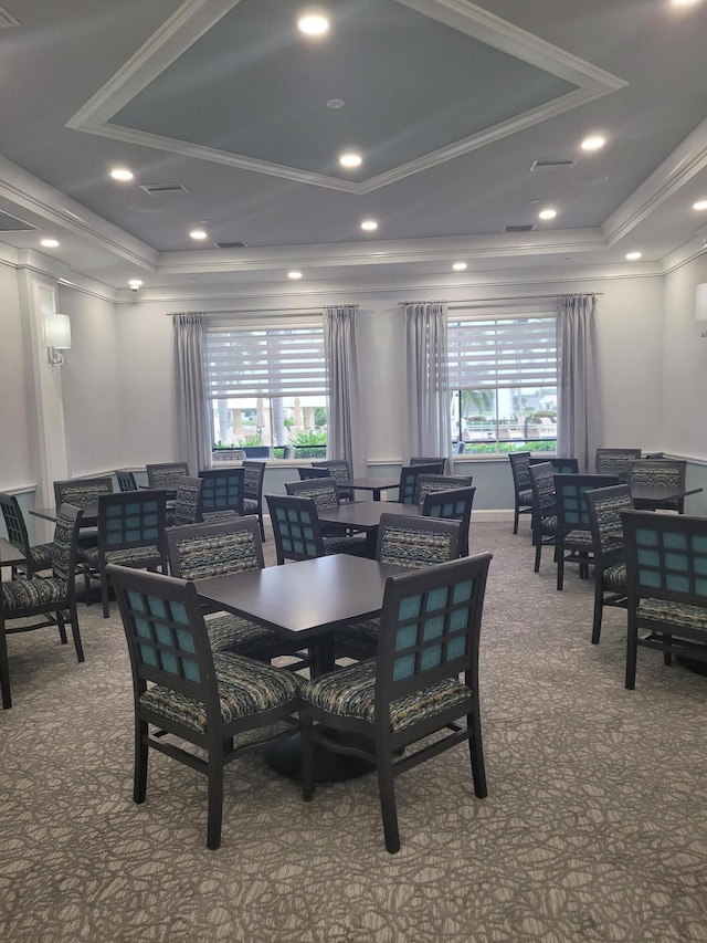 dining area featuring ornamental molding, carpet floors, a tray ceiling, and a healthy amount of sunlight