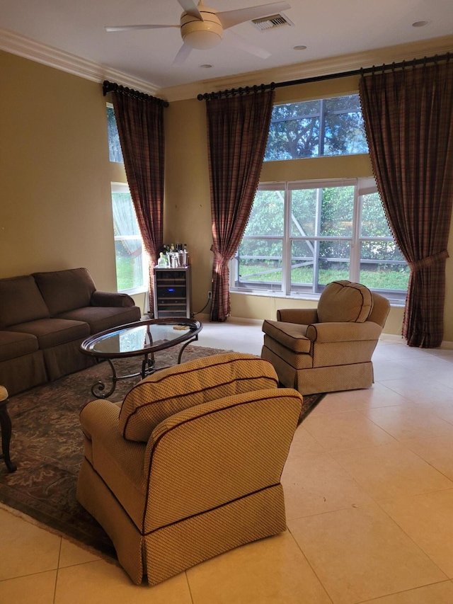 living room with ceiling fan, light tile patterned floors, crown molding, and a wealth of natural light