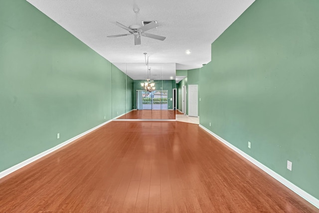 unfurnished living room with hardwood / wood-style flooring, a textured ceiling, and ceiling fan with notable chandelier