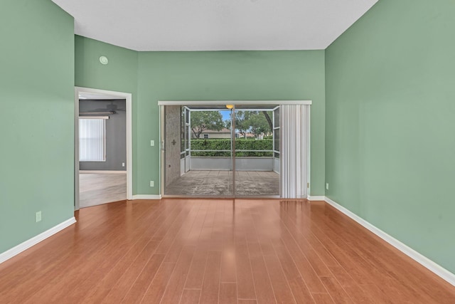 empty room with plenty of natural light and hardwood / wood-style floors