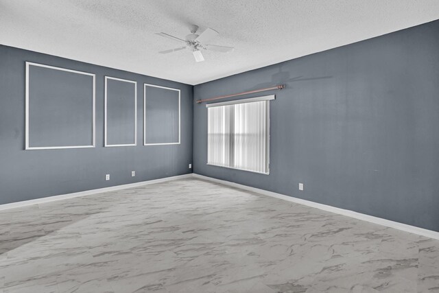 unfurnished room featuring ceiling fan and a textured ceiling