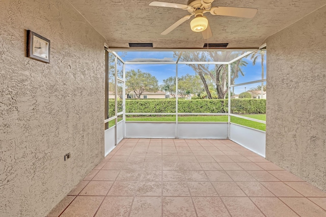 unfurnished sunroom with ceiling fan