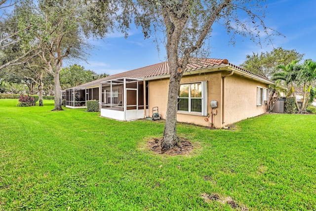 back of property featuring a lawn and a sunroom