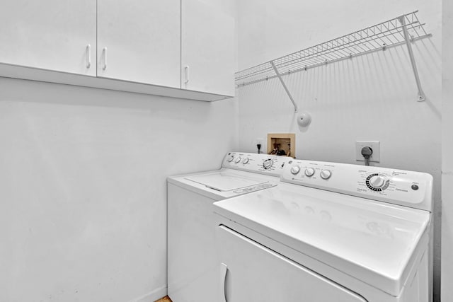 washroom featuring cabinets and separate washer and dryer