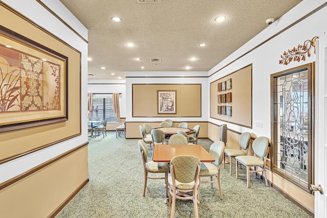 dining room with carpet and a textured ceiling