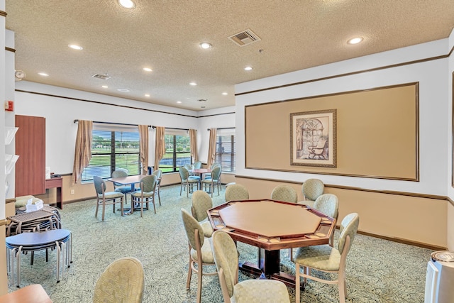 dining space with carpet and a textured ceiling