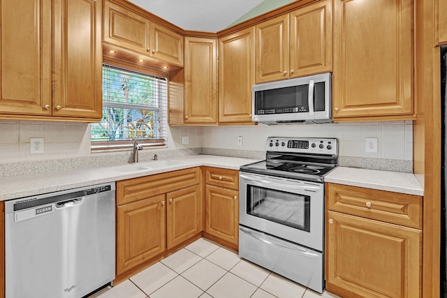 kitchen featuring a textured ceiling, decorative backsplash, stainless steel appliances, and light tile patterned floors