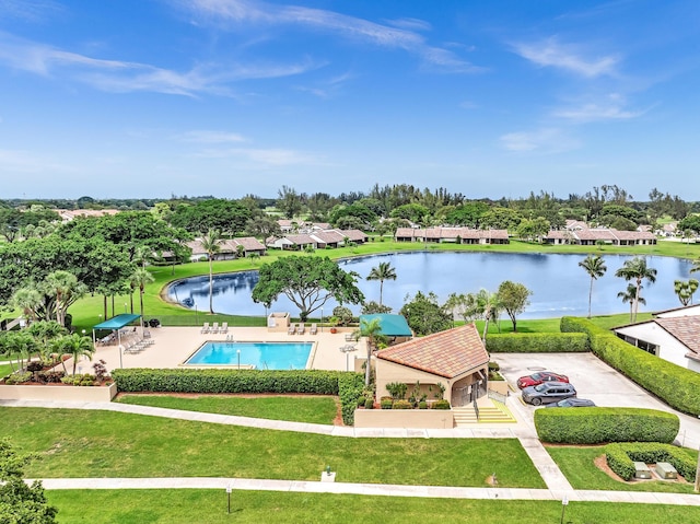 exterior space featuring a water view, a yard, and a pool