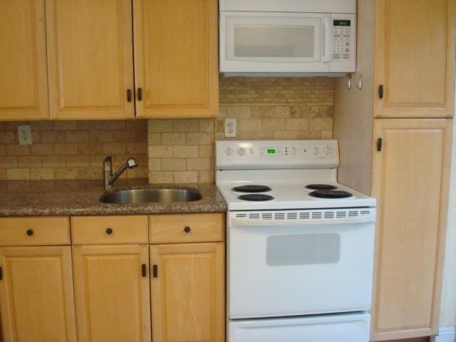 kitchen featuring sink, light brown cabinets, white appliances, and tasteful backsplash