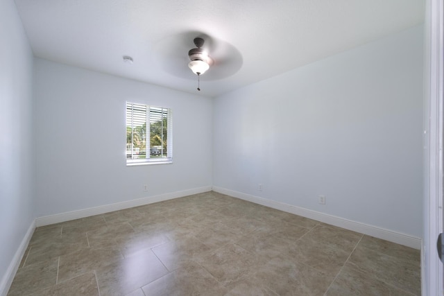 tiled spare room featuring ceiling fan