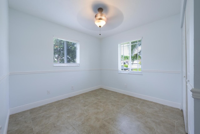 unfurnished room featuring ceiling fan and a wealth of natural light