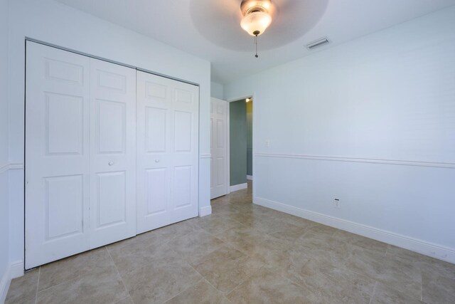 unfurnished bedroom featuring ceiling fan and a closet