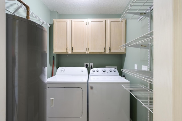 laundry area with washer and dryer, cabinets, and a textured ceiling