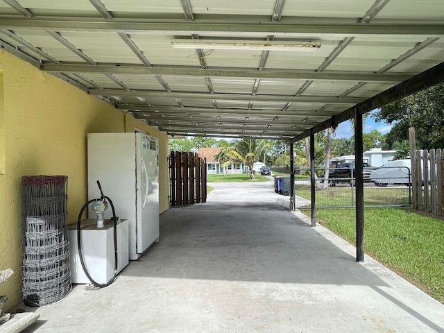 exterior space with white refrigerator and a carport