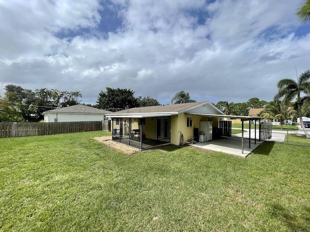 back of house with a patio area, a yard, and a sunroom