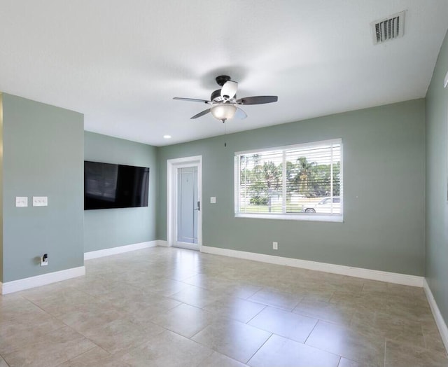 empty room with ceiling fan and light tile patterned flooring