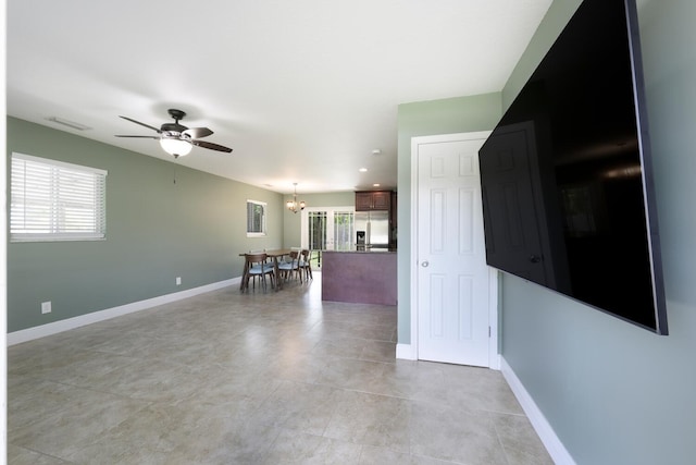 interior space featuring ceiling fan with notable chandelier