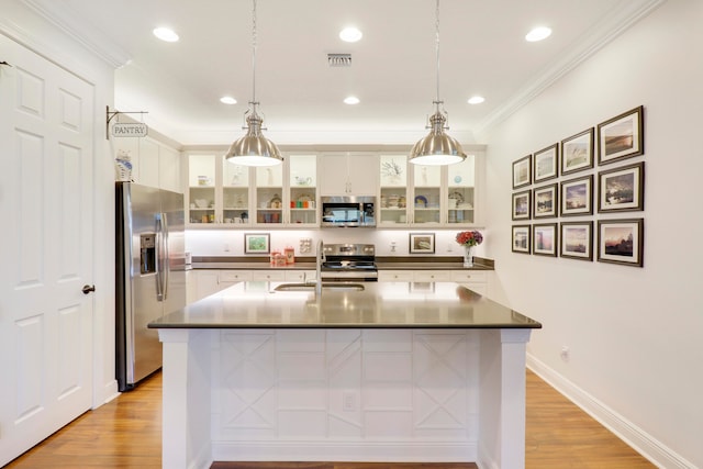 kitchen with sink, appliances with stainless steel finishes, white cabinets, and light hardwood / wood-style floors