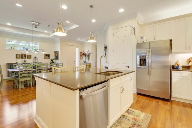 kitchen featuring light hardwood / wood-style flooring, stainless steel appliances, sink, and an island with sink