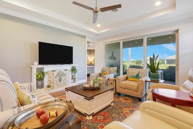 living room featuring ornamental molding, hardwood / wood-style flooring, a raised ceiling, and ceiling fan