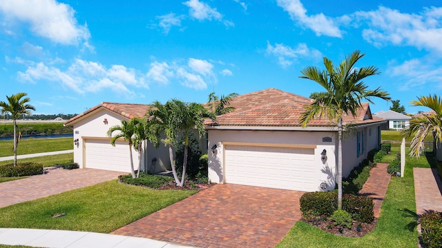 mediterranean / spanish-style home featuring a front lawn and a garage