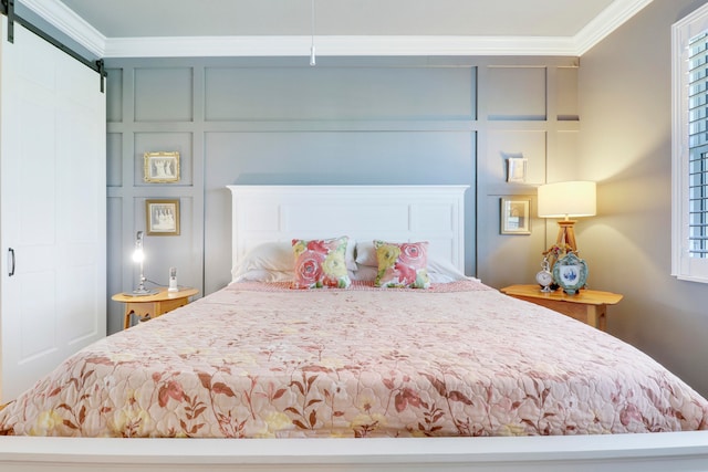 bedroom with ornamental molding and a barn door