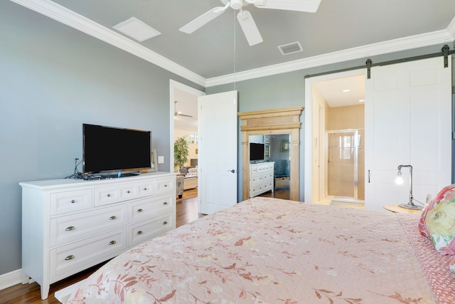 bedroom featuring dark hardwood / wood-style flooring, ceiling fan, a barn door, ornamental molding, and ensuite bathroom