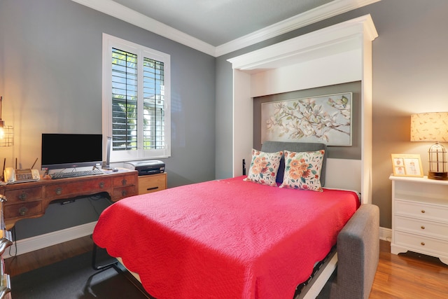 bedroom featuring crown molding, hardwood / wood-style flooring, and multiple windows