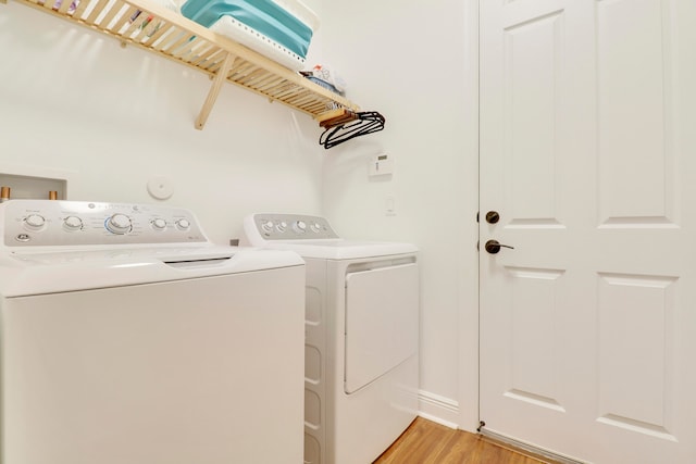 laundry area featuring light hardwood / wood-style flooring and washer and clothes dryer