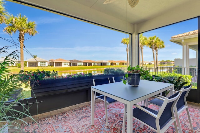 view of patio with a water view and ceiling fan