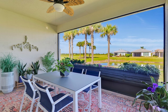 sunroom featuring a water view and ceiling fan