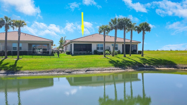 rear view of property with a lawn and a water view