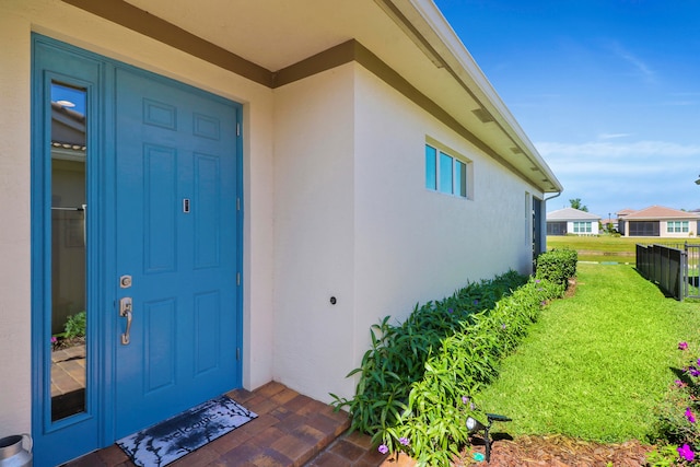 property entrance featuring a lawn