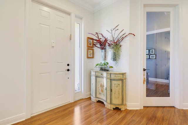 foyer entrance featuring hardwood / wood-style floors and crown molding